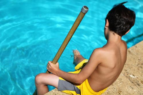 Un enfant au bord de la piscine avec un bracelet alarme